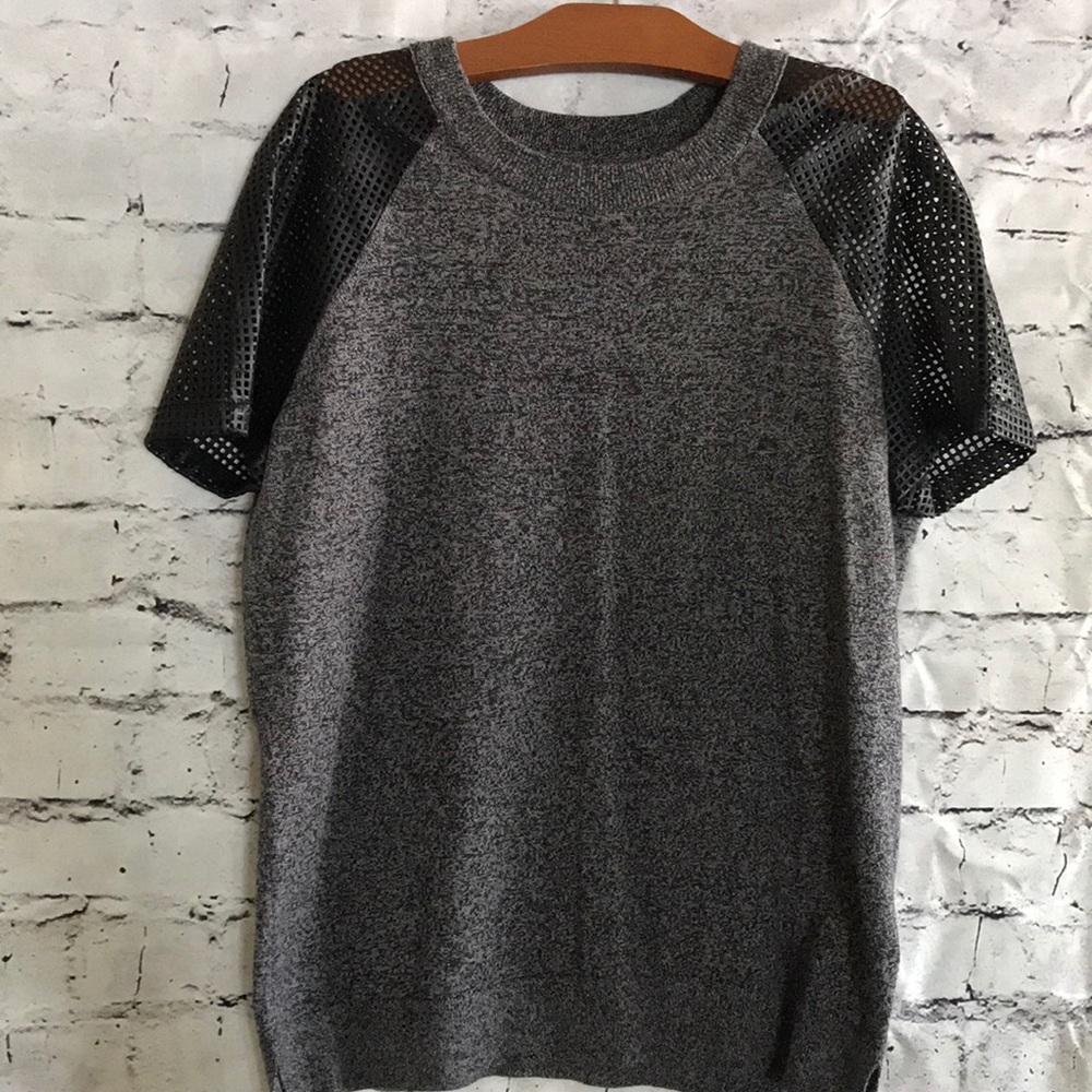 Women’s sweater knit top with mesh inlay sleeves.